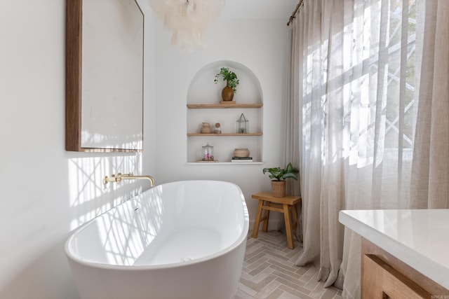 bathroom with a freestanding bath and brick floors