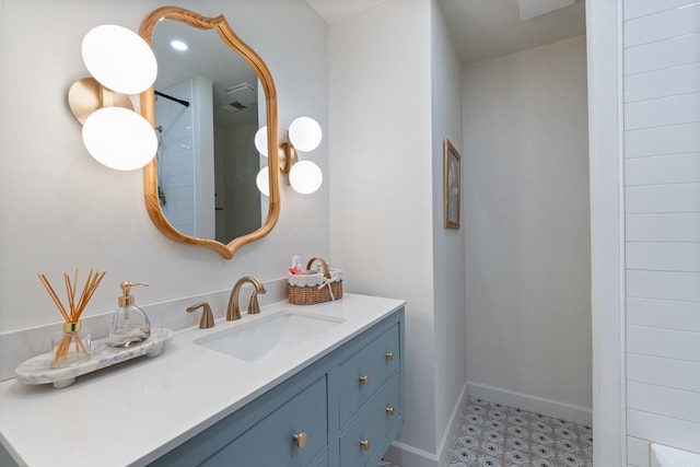 bathroom with vanity, baseboards, and a shower