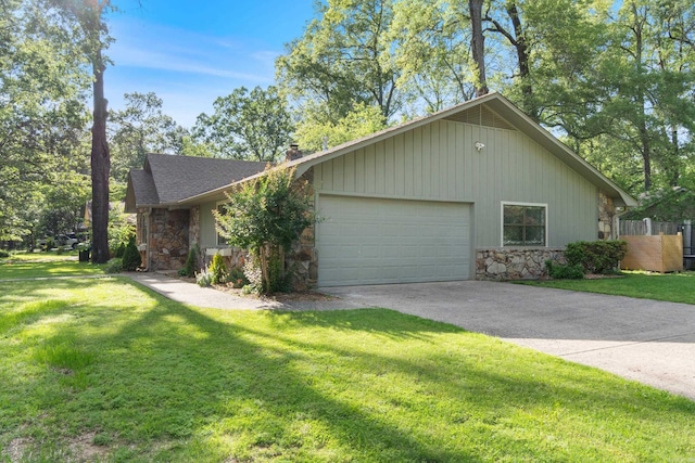 view of property exterior featuring stone siding, an attached garage, driveway, and a lawn