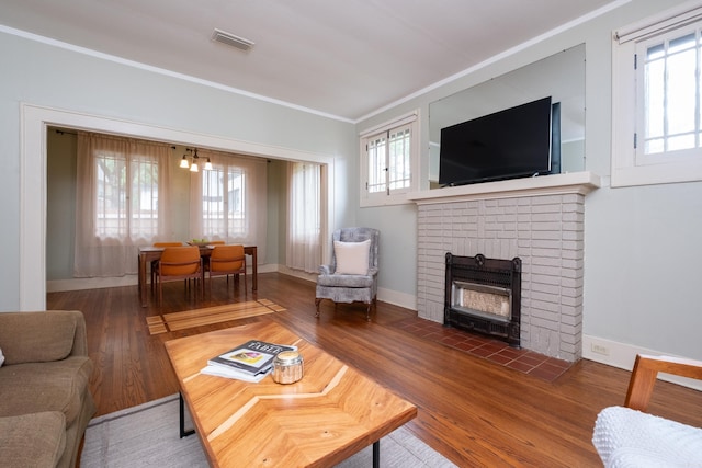 5200 I St, Little Rock, AR 72205 - living area featuring ornamental molding, healthy amount of natural light, a brick fireplace, wood finished floors, and baseboards