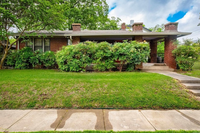 5200 I St, Little Rock, AR 72205 - view of front facade featuring brick siding, a front yard, and a chimney