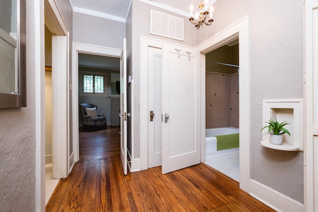 5200 I St, Little Rock, AR 72205 - hallway with wood finished floors, a chandelier, crown molding, a textured wall, and baseboards