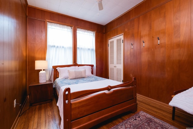 5200 I St, Little Rock, AR 72205 - bedroom with hardwood / wood-style floors, wood walls, a closet, and a ceiling fan