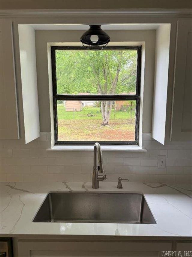 3705 E 6th St, Russellville, AR 72802 - kitchen view of a sink, tasteful backsplash, light stone countertops, and white cabinets