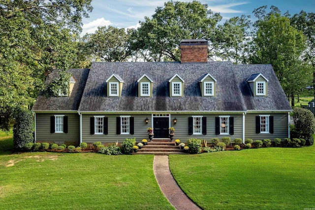 new england style home with a front lawn, a chimney, and a shingled roof