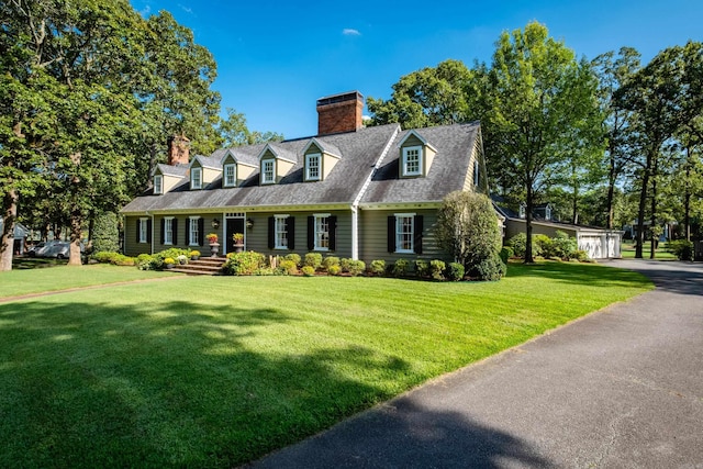 cape cod house with a chimney and a front lawn