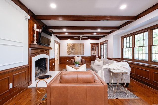 living area featuring a fireplace, wainscoting, wood finished floors, beamed ceiling, and recessed lighting