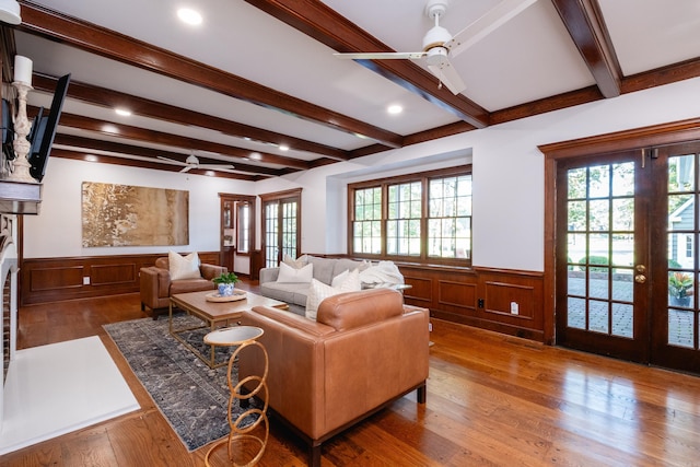 living room with a ceiling fan, beamed ceiling, wainscoting, wood finished floors, and recessed lighting