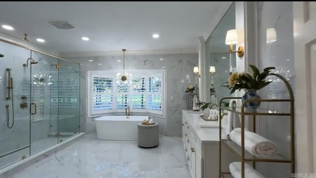 full bath with marble tiled floors, a stall shower, a freestanding tub, vanity, and recessed lighting
