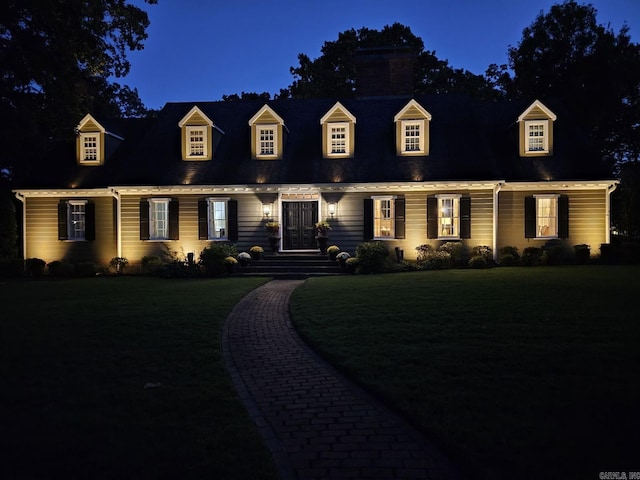 cape cod-style house with a yard and a chimney