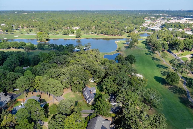 view of property location with a heavily wooded area, a large body of water, and a local golf course