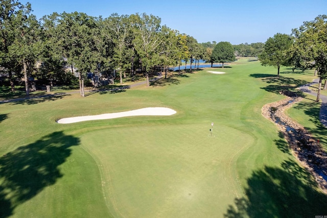 view of property's community with view of scattered trees and view of golf course