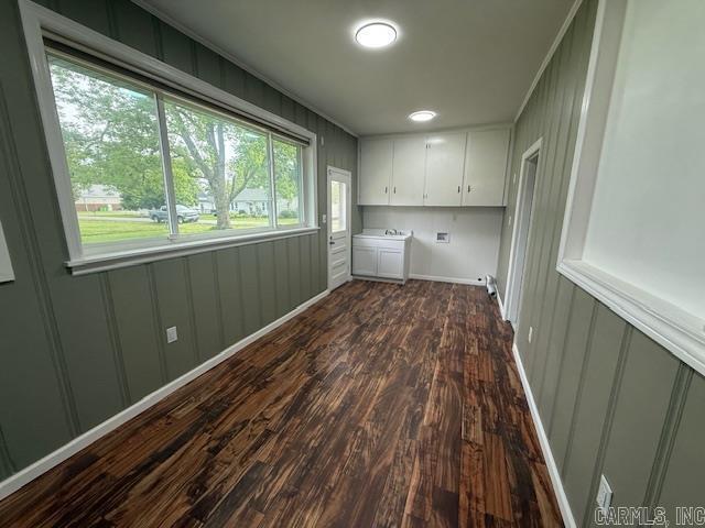 307 E 5th St, Carlisle, AR 72024 - washroom with cabinet space, dark wood finished floors, washing machine and clothes dryer, a decorative wall, and baseboards