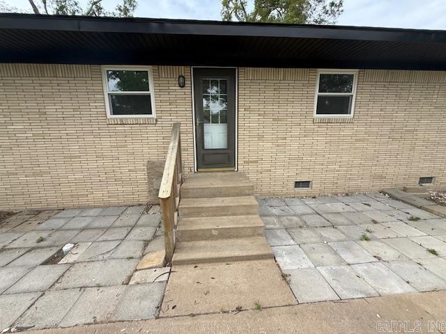 307 E 5th St, Carlisle, AR 72024 - property entrance featuring crawl space, a patio, and brick siding