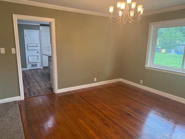 307 E 5th St, Carlisle, AR 72024 - spare room featuring dark wood-style floors, ornamental molding, baseboards, and a chandelier