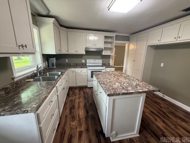 307 E 5th St, Carlisle, AR 72024 - kitchen featuring white electric stove, a sink, dark wood-style floors, white cabinetry, and a center island