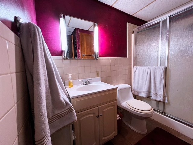 96 E Lakeshore Dr, Cherokee Village, AR 72529 - bathroom featuring a stall shower, toilet, tile walls, vanity, and a paneled ceiling