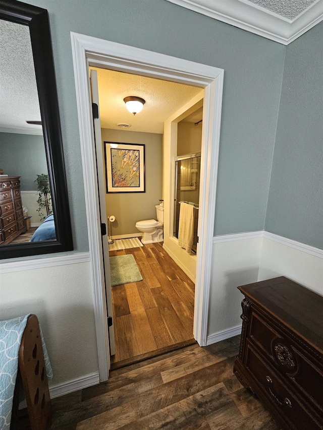 hall with dark wood finished floors, a textured ceiling, and baseboards
