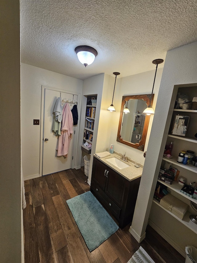 full bath with wood finished floors, a textured ceiling, and vanity