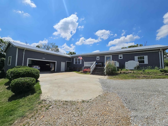 view of front of home with an attached garage, metal roof, and concrete driveway