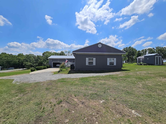view of home's exterior with a garage, driveway, and a lawn