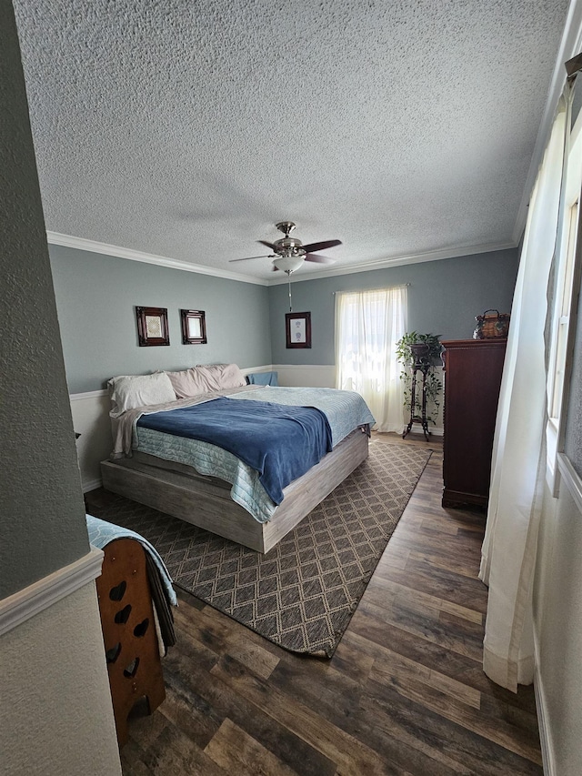 bedroom featuring wood finished floors, ornamental molding, a textured ceiling, and a ceiling fan