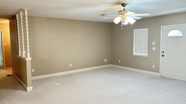 entryway with light colored carpet, a ceiling fan, and baseboards