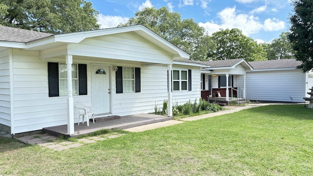 view of front of house with a front lawn, roof with shingles, and covered porch