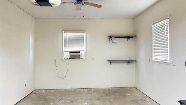 unfurnished room featuring unfinished concrete flooring, a ceiling fan, plenty of natural light, and cooling unit
