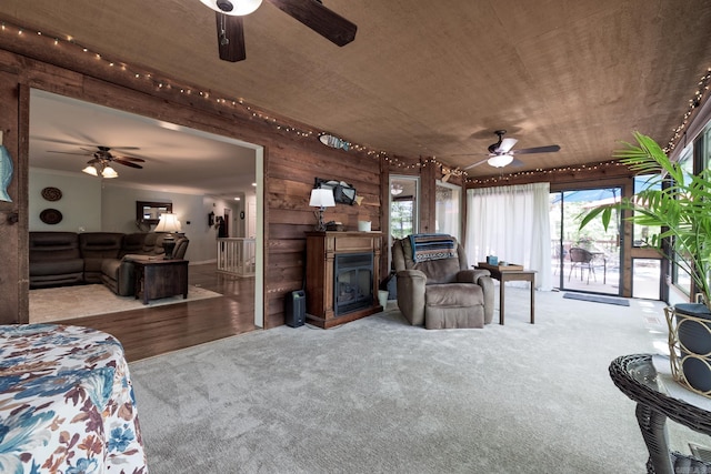 3 Tenerife Way, Hot Springs Village, AR 71909 - living room featuring a ceiling fan, carpet flooring, wooden ceiling, wood walls, and a fireplace