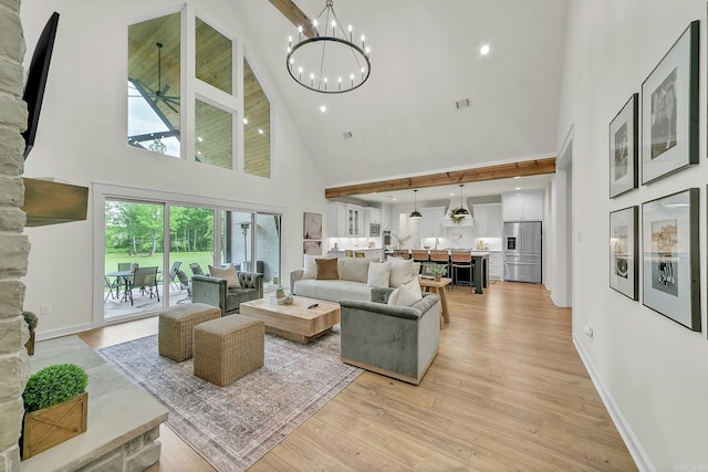 living area featuring high vaulted ceiling, a chandelier, light wood-style flooring, and baseboards