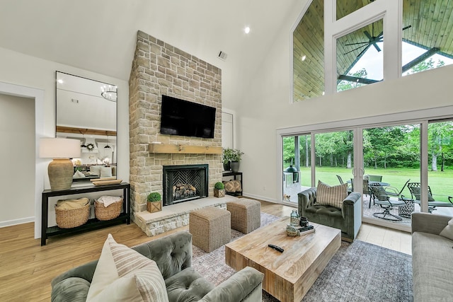 living area with high vaulted ceiling, wood finished floors, and healthy amount of natural light