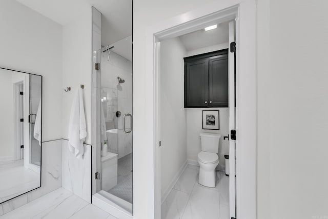 bathroom with a shower stall, toilet, baseboards, and marble look tile flooring