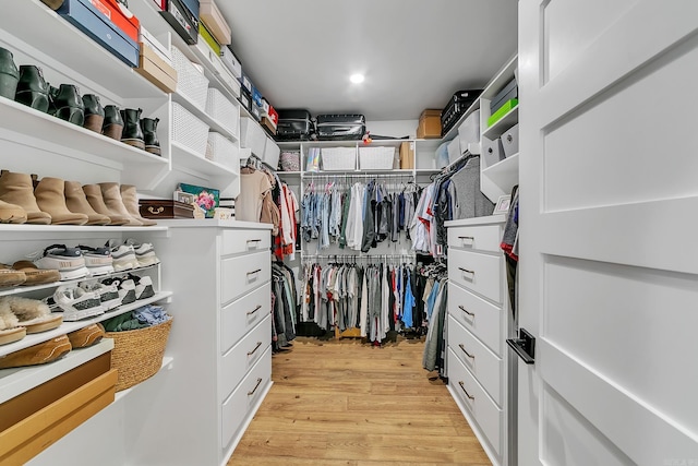 walk in closet with light wood finished floors