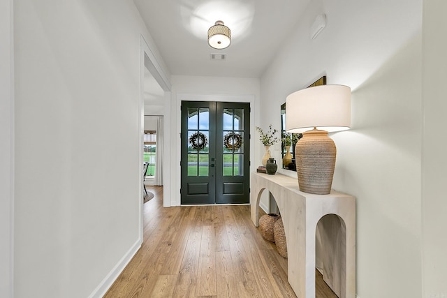 entryway featuring french doors, light wood-type flooring, and baseboards