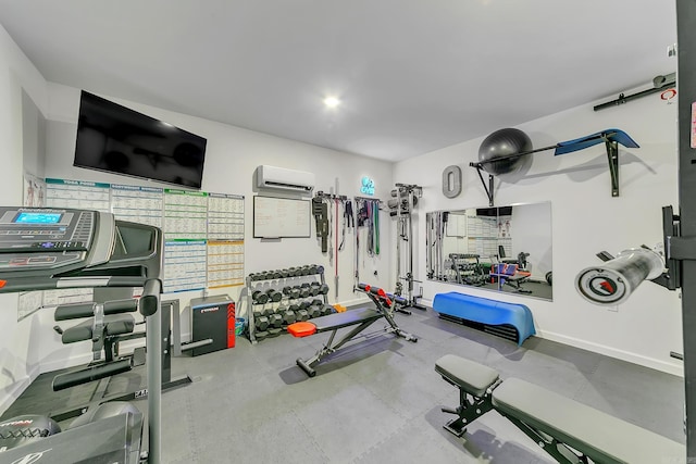 workout room featuring an AC wall unit and baseboards