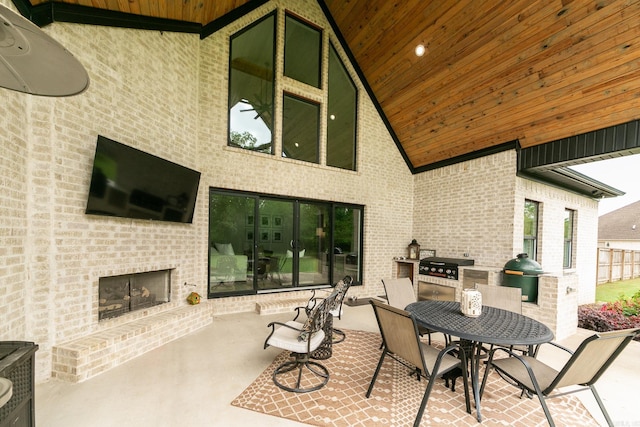 view of patio / terrace featuring an outdoor brick fireplace, grilling area, area for grilling, and outdoor dining space