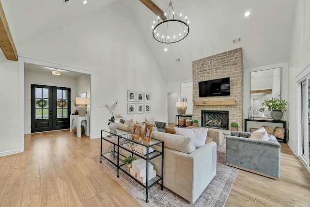 living room with high vaulted ceiling, a fireplace, a chandelier, light wood-style floors, and recessed lighting