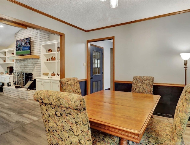 72 Pintuerero Way, Hot Springs Village, AR 71909 - dining room with wood finished floors, a brick fireplace, lofted ceiling, a textured ceiling, and crown molding