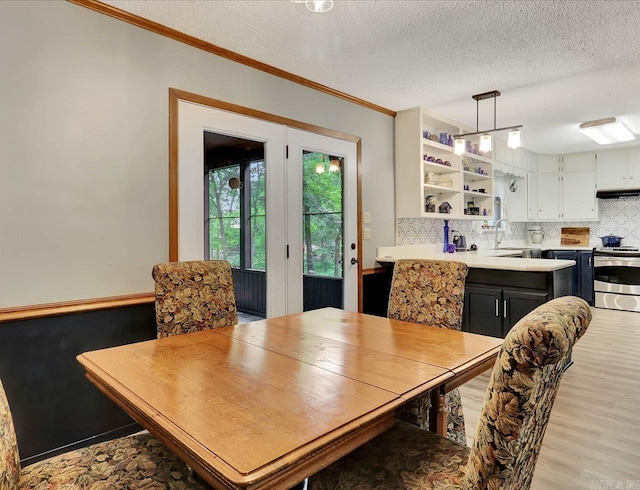 72 Pintuerero Way, Hot Springs Village, AR 71909 - dining area featuring light wood finished floors, ornamental molding, and a textured ceiling