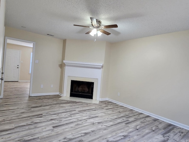 1807 Reservoir, Little Rock, AR 72227 - unfurnished living room featuring wood finished floors, a ceiling fan, a textured ceiling, and a fireplace with flush hearth