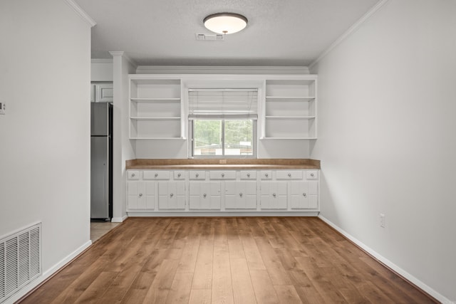 1121 Twin Pts Unit 1121C, Hot Springs, AR 71913 - kitchen with freestanding refrigerator, open shelves, crown molding, wood finished floors, and white cabinets