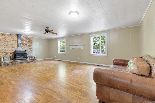 7606 Westwood Ave, Little Rock, AR 72204 - living area featuring a wood stove, light wood-type flooring, crown molding, and a ceiling fan