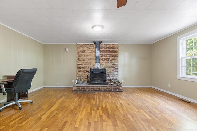 7606 Westwood Ave, Little Rock, AR 72204 - living area with wood finished floors, a wood stove, and ornamental molding