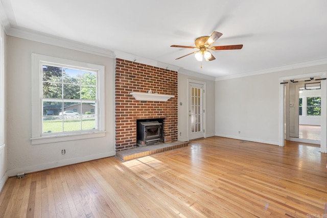 7606 Westwood Ave, Little Rock, AR 72204 - unfurnished living room with a wood stove, baseboards, wood-type flooring, plenty of natural light, and ornamental molding