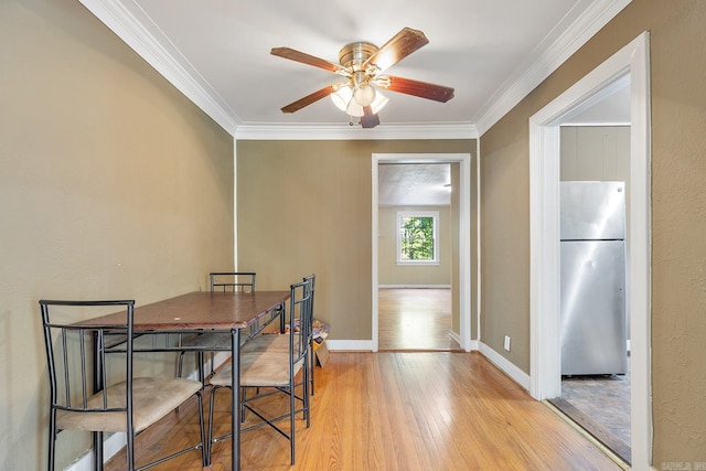 7606 Westwood Ave, Little Rock, AR 72204 - dining space with light wood finished floors, ornamental molding, a ceiling fan, and baseboards