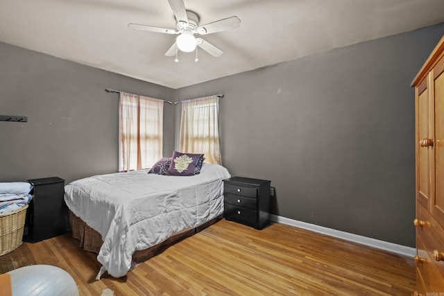 bedroom featuring wood finished floors, baseboards, and ceiling fan