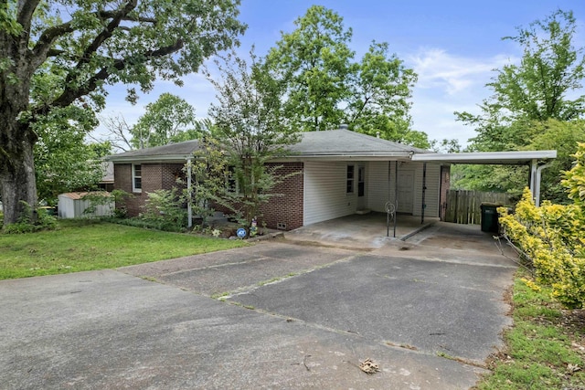 ranch-style home featuring asphalt driveway, an attached carport, and brick siding