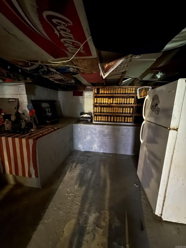 unfinished below grade area with freestanding refrigerator
