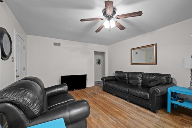 living room with light wood-type flooring, a ceiling fan, and baseboards